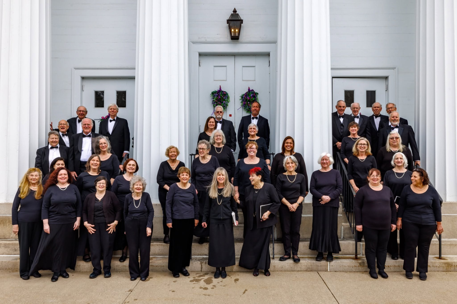 Cappella Cantorum members in concert dress on the church steps